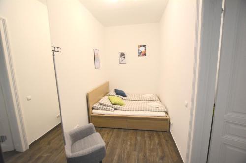 ウィーンにあるPrater & Center Apartment mit eigener Terrasseの小さなベッドルーム(ベッド1台、椅子付)