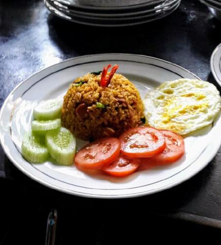 a plate of food with rice and vegetables on a table at Dago Teuku Angkasa 14 in Bandung