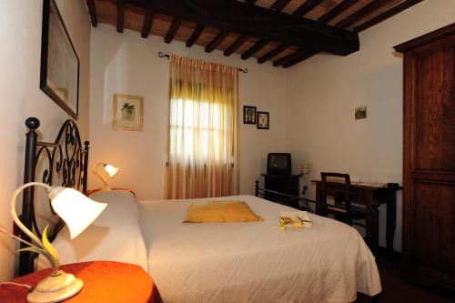 a bedroom with a bed and a desk and a window at Agriturismo Il Sasso in Anghiari