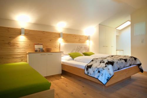 a bedroom with a bed with a wooden wall at LEO Appartements in Mayrhofen