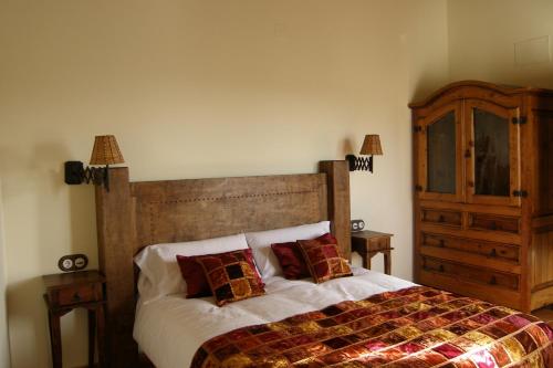 a bedroom with a large bed with two pillows at Casa Rural El Zahorí De Pinedas in Pinedas