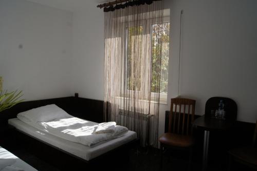 a bedroom with a bed and a window and a chair at Uslugi hotelowe A1 in Łódź