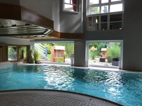 a large swimming pool with blue water in a house at Romantisches Hotel Menzhausen in Uslar