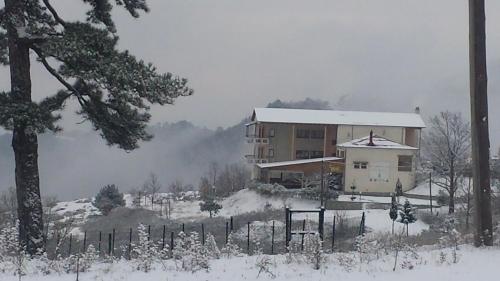 a house in the snow next to a fence at Panorama Kakopleyri Kalabakas in Kakoplévrion