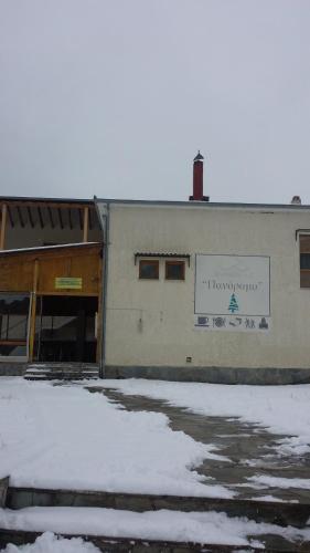 a building with snow in front of it at Panorama Kakopleyri Kalabakas in Kakoplévrion