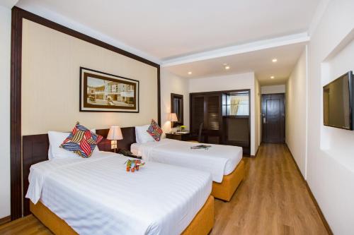 a hotel room with two beds and a television at Thang Long Espana Hotel in Hanoi