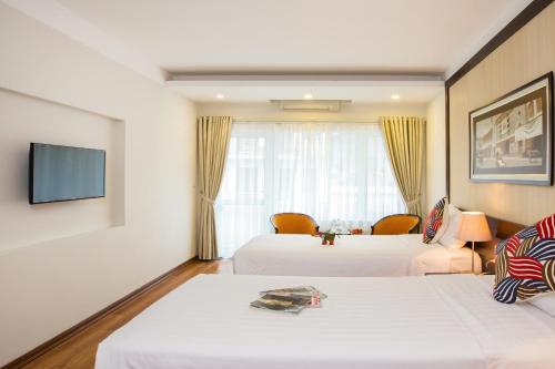 a hotel room with two beds and a tv at Thang Long Espana Hotel in Hanoi
