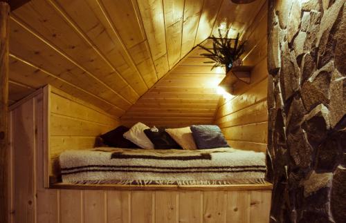 a bedroom in a log cabin with a bed in it at Camp Bilyi Slon in Dzembronya