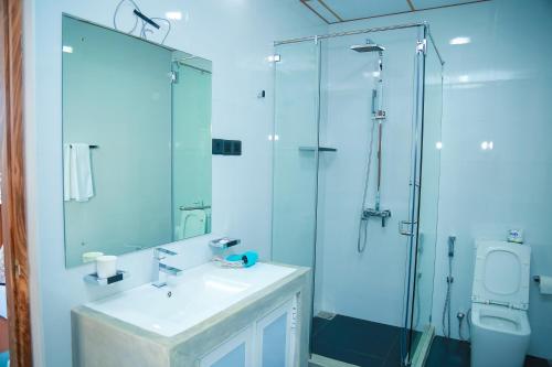 a bathroom with a glass shower and a sink at Funky Hotel in Hikkaduwa