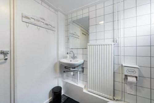 uma casa de banho branca com um lavatório e um espelho em Di'Mami House em Avenhorn
