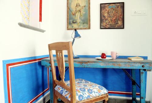 a blue table with a wooden chair and a blue table with a desk at Little Garden Guest House in Udaipur