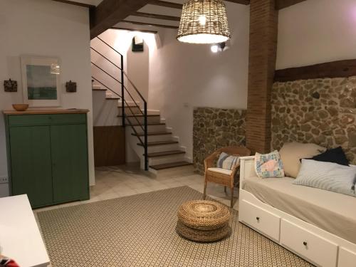 a living room with a couch and a staircase at Casa La Abuela in Chulilla