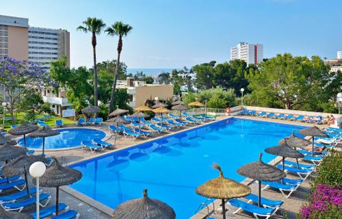 uma grande piscina com cadeiras e guarda-sóis em AluaSun Cala Antena - All Inclusive em Calas de Mallorca