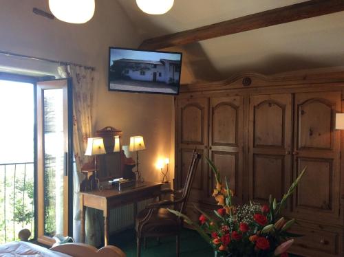 a living room with a television on a wall at Bretton Cottage in Eyam