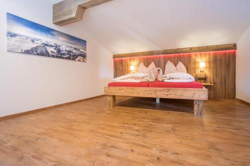 a bedroom with a red bed and a wooden bench at Chalet Holzerstubn in Ehrwald