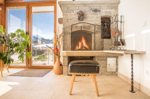 a stone fireplace with a chair in front of it at Chalet Holzerstubn in Ehrwald