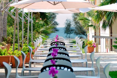 a row of chairs and umbrellas on a patio at Paestum Inn Beach Resort in Paestum