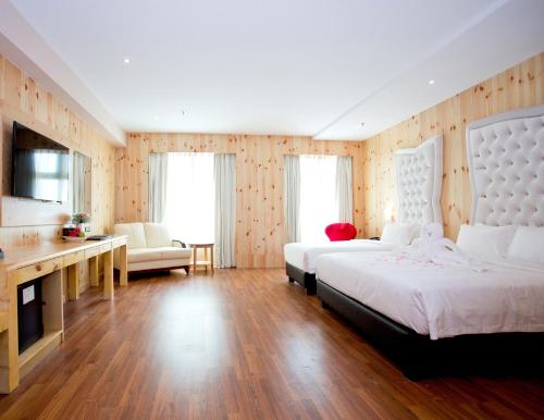 a large bedroom with two beds and a television at Vouk Hotel Suites, Penang in George Town