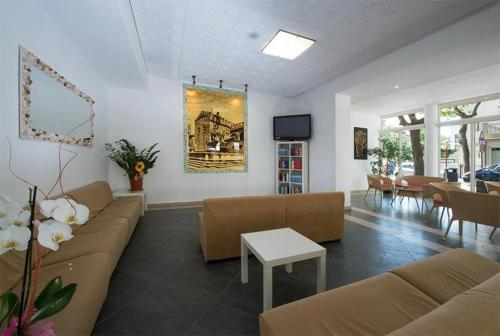 un grand salon avec des canapés et une télévision dans l'établissement Hotel Nettuno, à Misano Adriatico