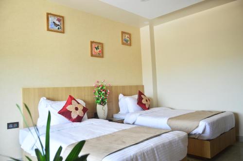 a hotel room with two beds and a plant at Hotel Royal Palace in Bishnāth