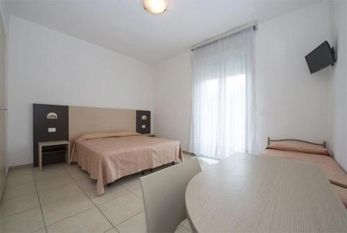 - une chambre avec un lit et une table dans l'établissement Hotel Nettuno, à Misano Adriatico