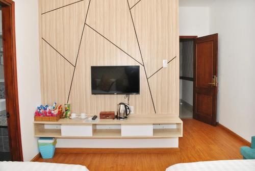 a living room with a tv on a wooden wall at Phi Long Hotel in Tuy Hoa