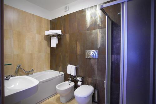 a bathroom with a toilet and a tub and a sink at Catania Hills Residence in San Gregorio di Catania