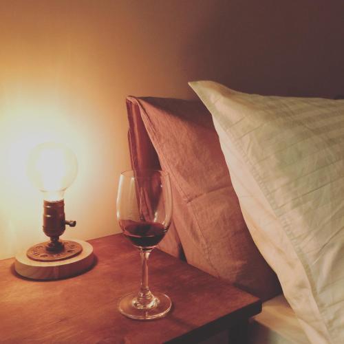 a glass of wine on a table next to a pillow at Lin's Inn in Ruisui