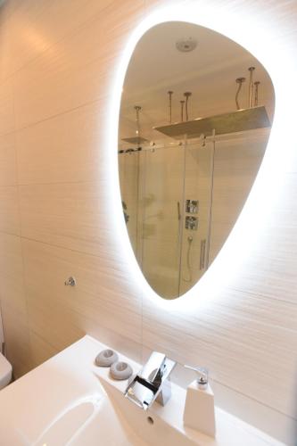 a bathroom with a white sink and a mirror at Apartment Wave -Luxury massage chair-Infrared Sauna, Parking with video surveillance, Entry with PIN 0 - 24h, FREE CANCELLATION 24 hours before Check In, Premium pillows and mattress in Slavonski Brod