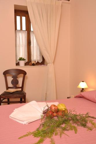a bowl of fruit on a bed with a window at Anatoli Labreon in Agia Marina