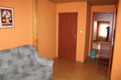 a living room with a couch and a wooden door at Zagroda Agroturystyczna Wiecha in Mieroszów