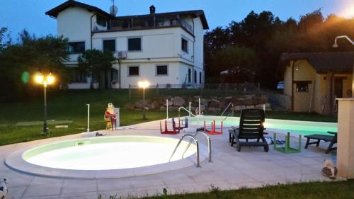 a pool in front of a house with a swimming poolitures at Cascina Rosa Camilla in Carpeneto