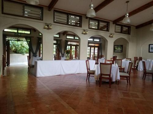 a banquet hall with white tables and chairs at Ufulu Gardens Hotel in Lilongwe