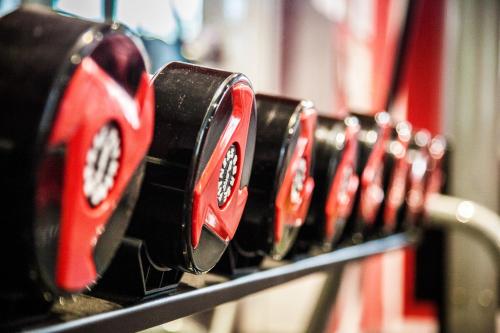 a row of red and black buttons on a machine at Gorse Hill Hotel in Woking