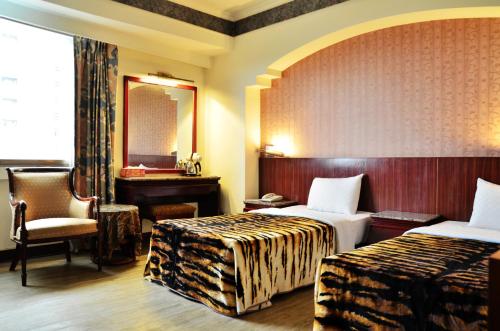台南的住宿－哥爸妻夫商務飯店-林森館 ，酒店客房,设有两张床和镜子