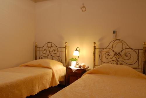 a bedroom with two beds and a lamp on a table at Anatoli Labreon in Agia Marina