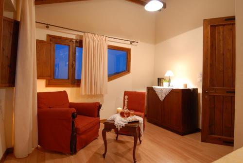 a living room with a red chair and a table at Anatoli Labreon in Agia Marina