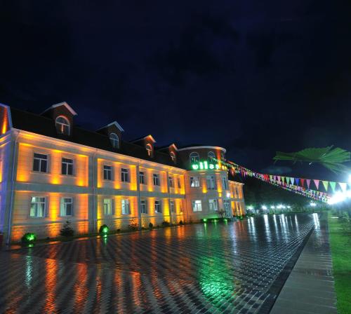 a building lit up at night with christmas lights at Vilesh Palace Hotel in Masallı