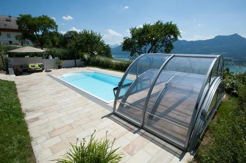 a swimming pool with a glass enclosure around it at Gesundheitshof Lohninger in Mondsee