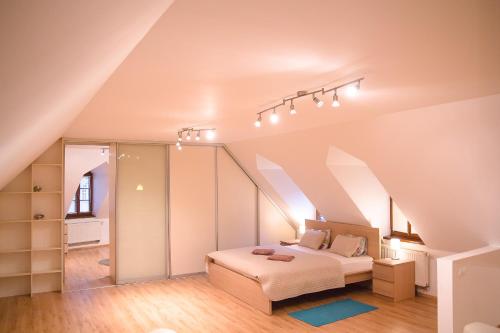 a attic bedroom with a bed and a staircase at Old Town Apartment in Trenčín