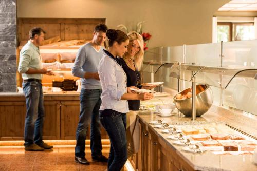 a group of people standing in a kitchen at Alpinresort ValSaa - Sport & Spa in Saalbach Hinterglemm
