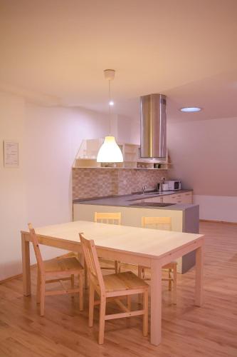 a kitchen with a wooden table and chairs in a room at Old Town Apartment in Trenčín