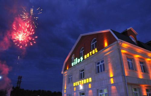 a building with a firework display in the sky at Vilesh Palace Hotel in Masallı