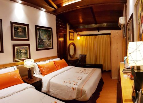 1 Schlafzimmer mit 2 Betten und einem Schreibtisch mit einem Spiegel in der Unterkunft Stay Amare Villa Maria 1 in Bacolod City