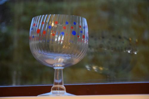 a clear wine glass with colorful dots on it at Teign Head Apartment in Newton Abbot