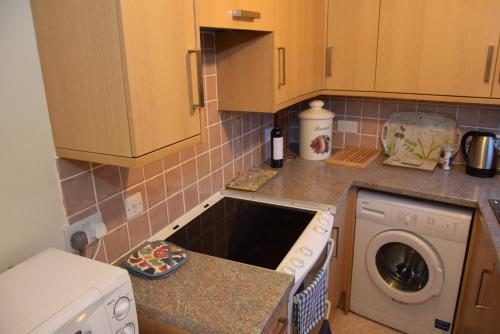 a kitchen with a dishwasher and a washer at Teign Head Apartment in Newton Abbot