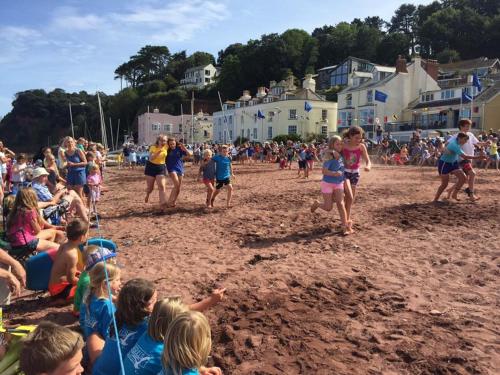 a group of children playing in the sand on a beach at Teign Head Apartment in Newton Abbot
