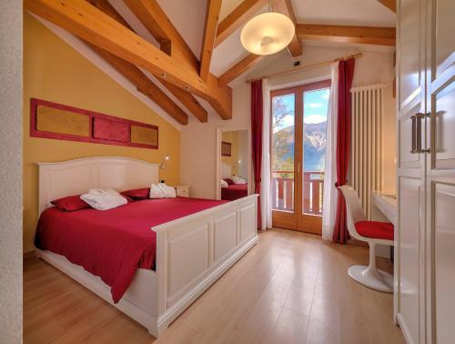 a bedroom with a large bed with a red blanket at Hotel Folgarida in Folgarida