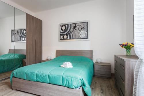 a bedroom with a green bed and a dresser at Il Filo di Arianna in Bologna
