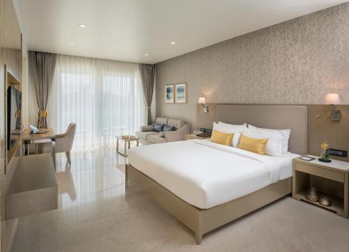 a bedroom with a large bed and a living room at Kabir Hotel & Spa in Vadodara